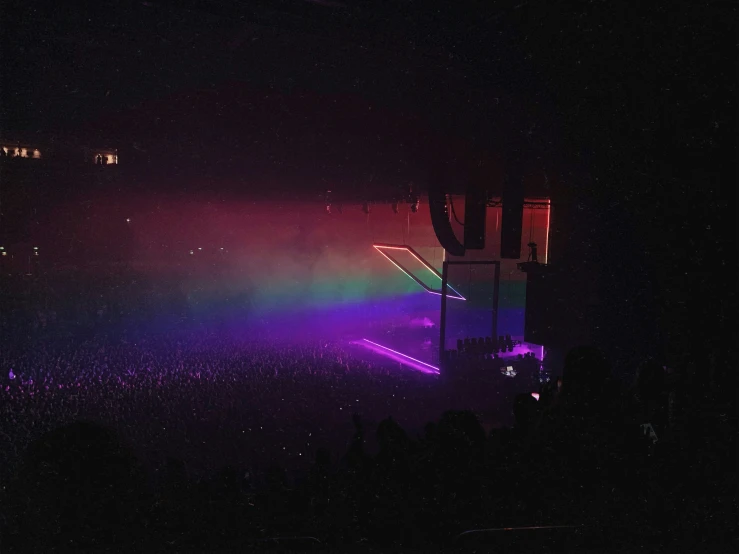 a concert scene with bright lights and a rainbow
