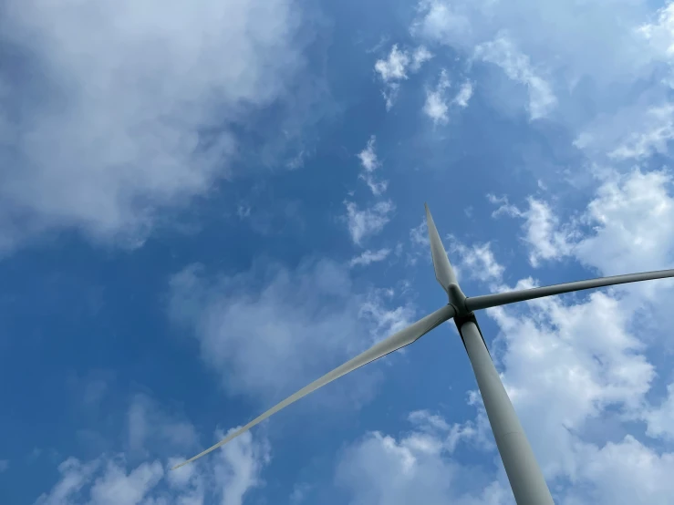 a wind turbine is shown in the middle of the blue sky