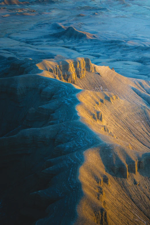 a mountain range covered in snow with the sun on it