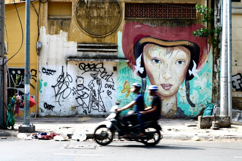 two people riding a motorcycle on a street