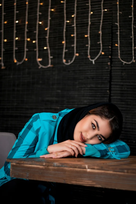 a girl leaning her head on the wooden table