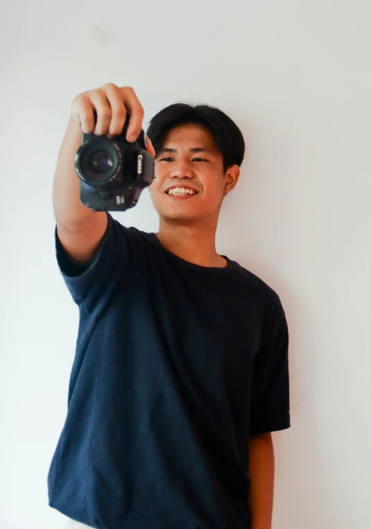 a young man standing up with a camera