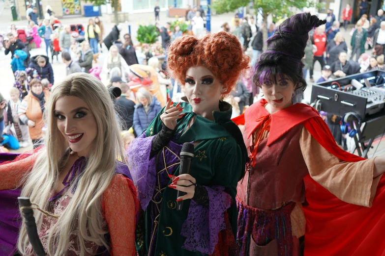 three women with red hair are dressed in costumes