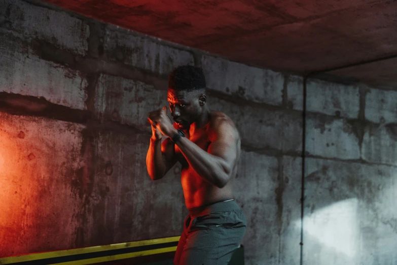 a shirtless man standing in front of a mirror with red light on