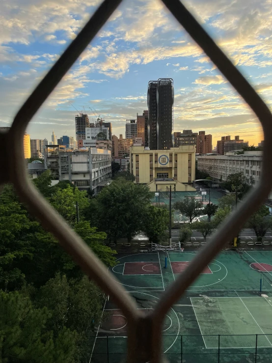 a city view through a fence with some buildings