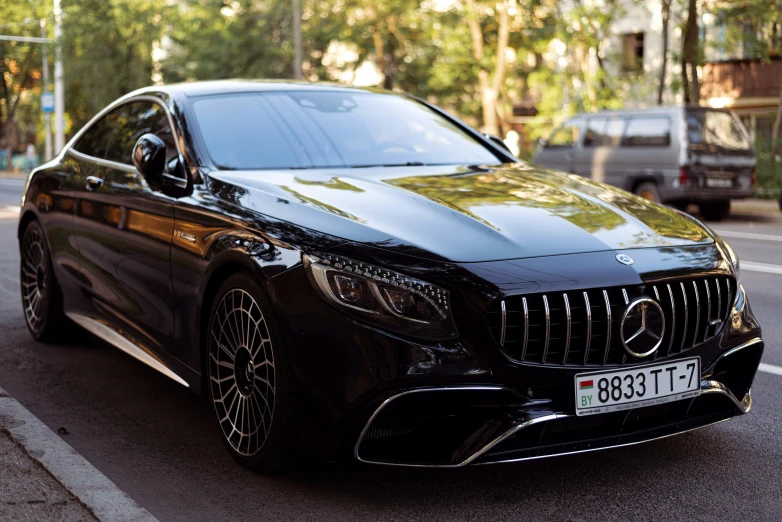 a black mercedes s - class is parked on the side of the street