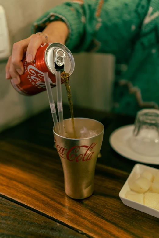 a person pouring cola onto an ice block