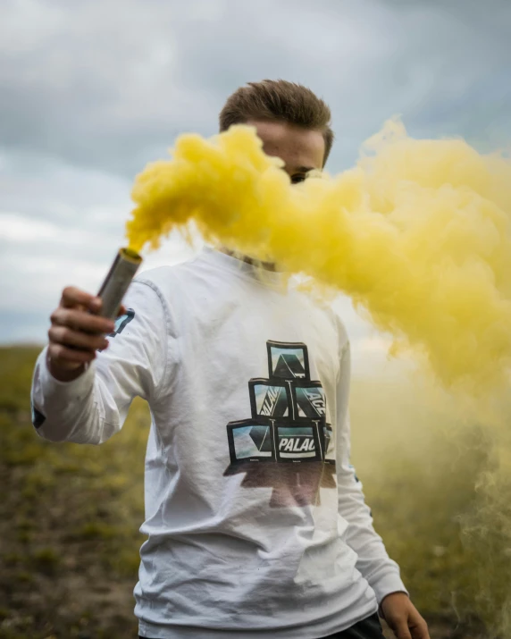 man with yellow smoke on his face holding a lighter