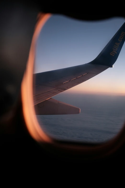 airplane window showing wing of the plane