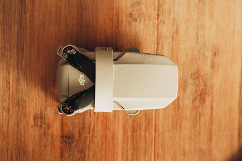 a white cordless device sitting on top of a wooden surface