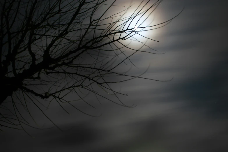 the sun is shining through the clouds behind trees