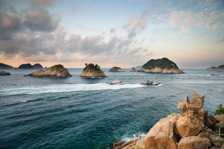 an ocean with some small rock outcrops in the background