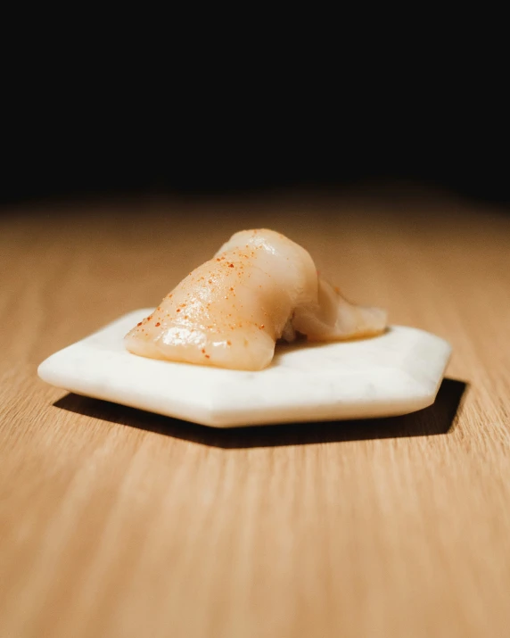 a white piece of food is laying on a table