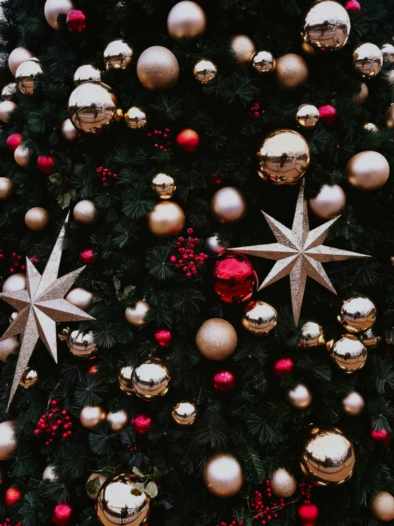 this is an christmas tree with red balls, stars, and ornaments