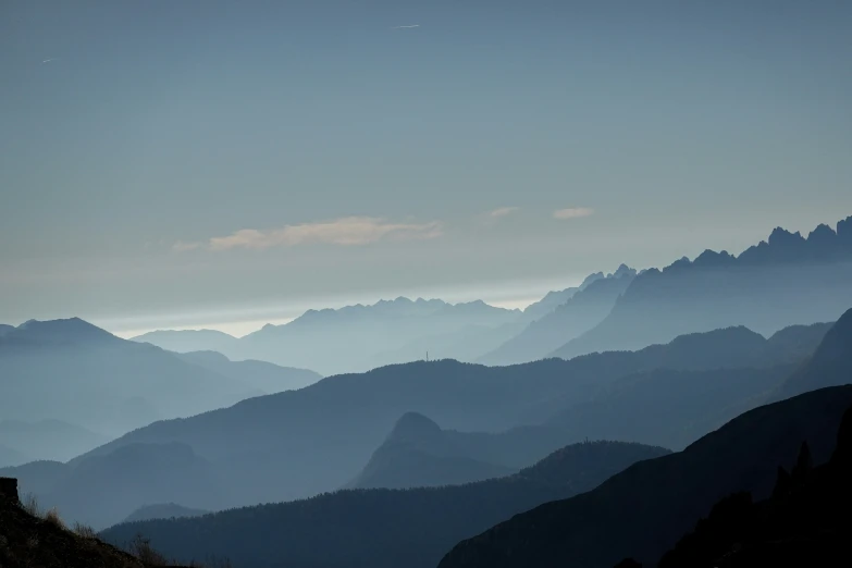 a blue and grey colored mountain range under a clear sky