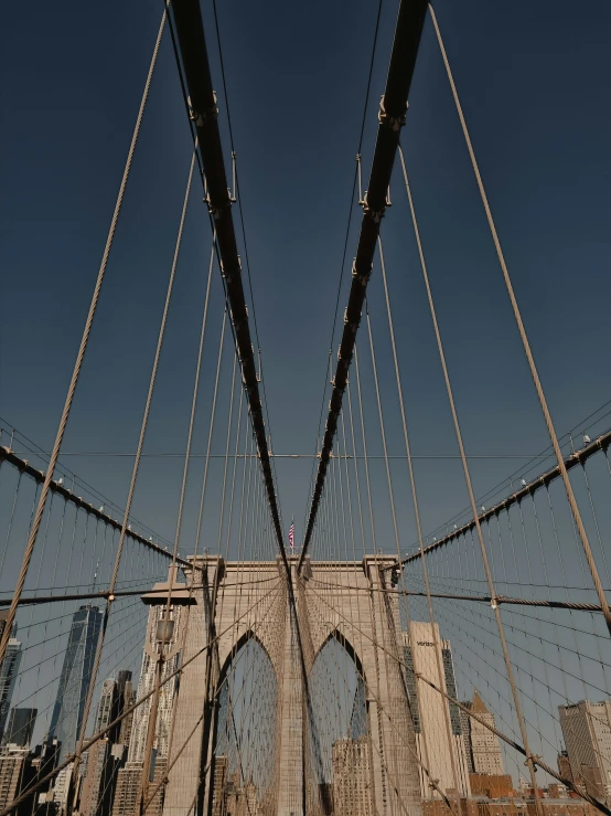 view of the brooklyn bridge from below the chain link