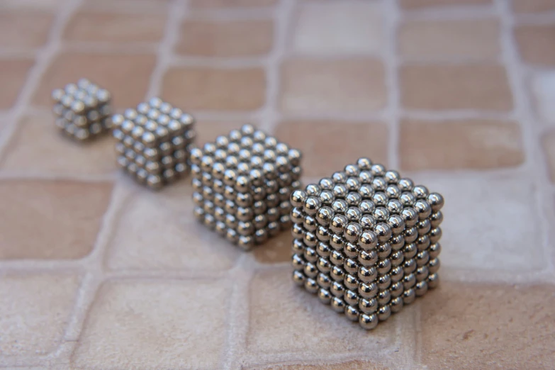 a set of six metal rubels sit on a tiled floor