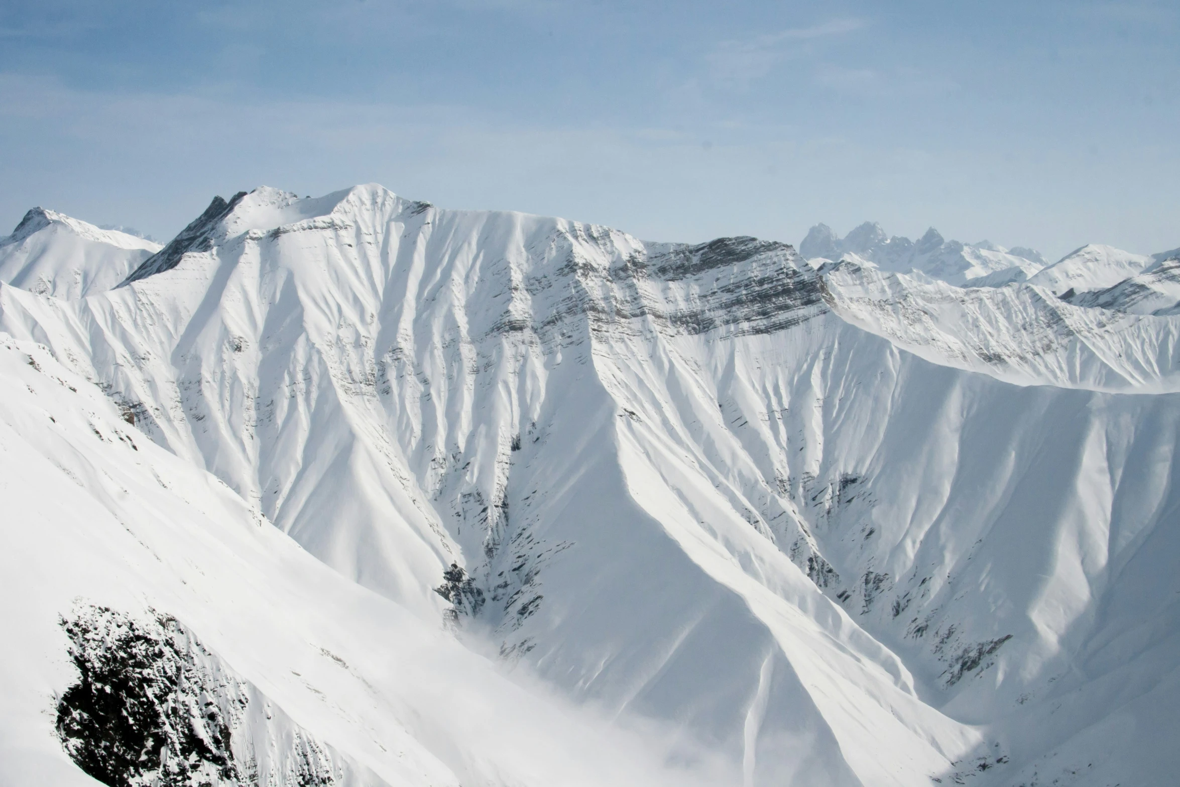 the view from a ski resort shows the huge peaks of the snowy mountains