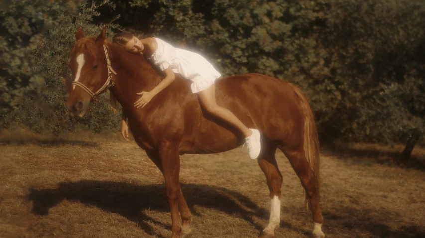 a girl rides on the back of a brown horse