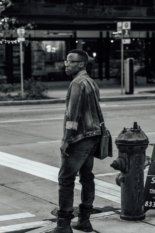 black and white pograph of man standing at curb corner