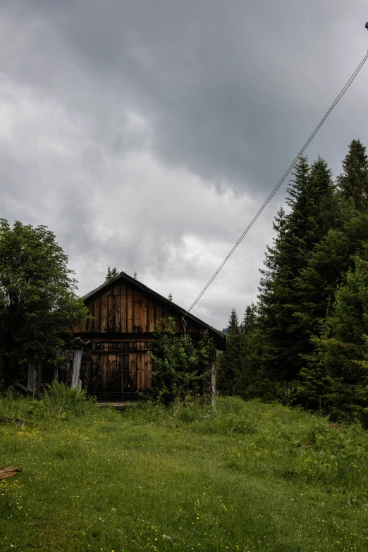 a small rustic wooden house with a big sky in the background