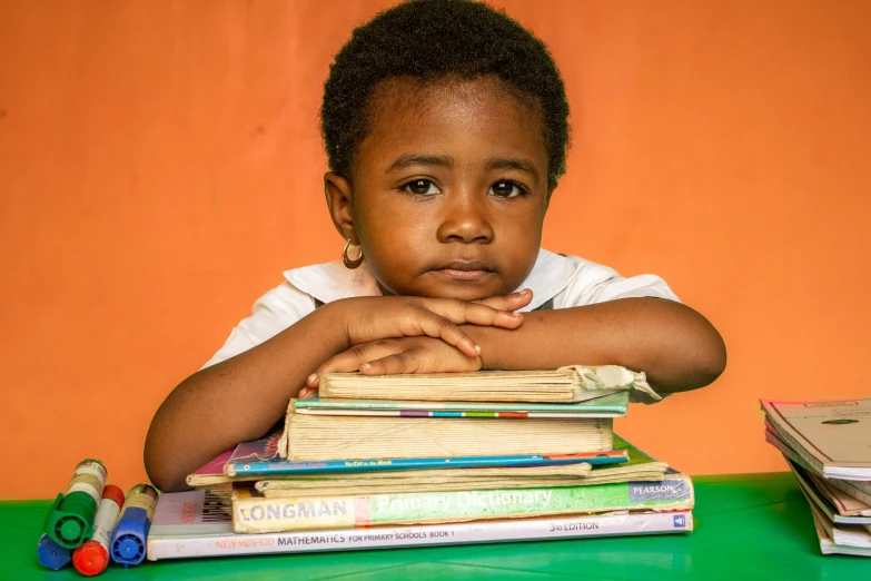 a young child in front of a pile of books