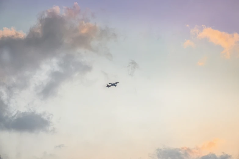 an airplane flying high in the sky above some clouds