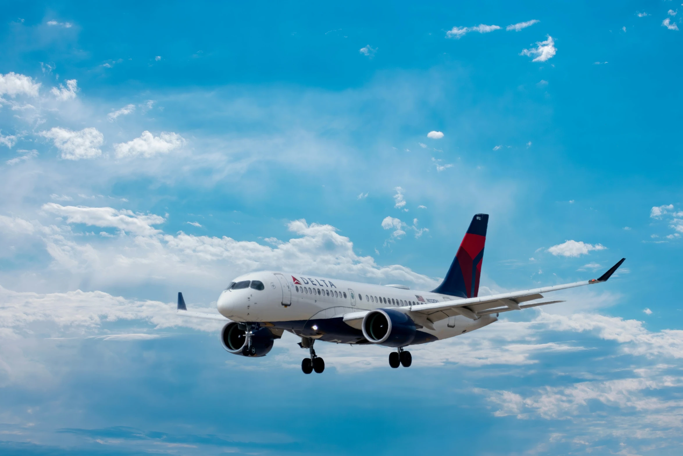 a plane taking off and the sky is partly cloudy