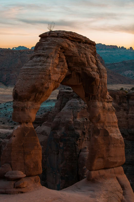 the sun set over a very tall rock formation