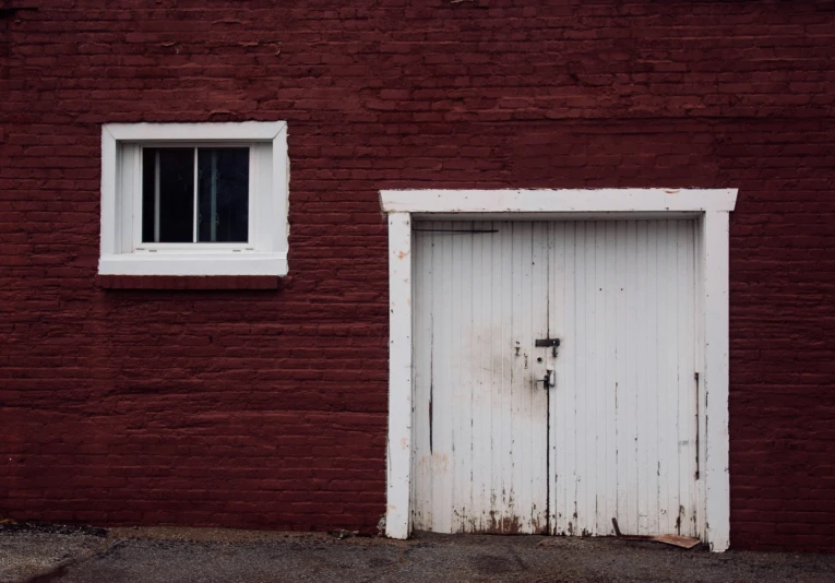 a brick wall with a boarded up door and window