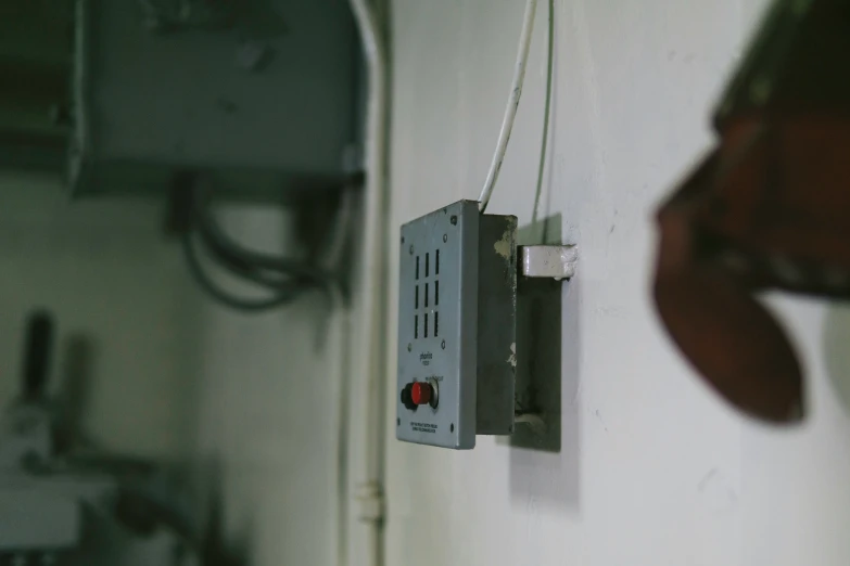 electrical wiring hanging from the wall and attached to a light switch