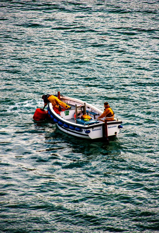 two men in boats on the water with blue skies