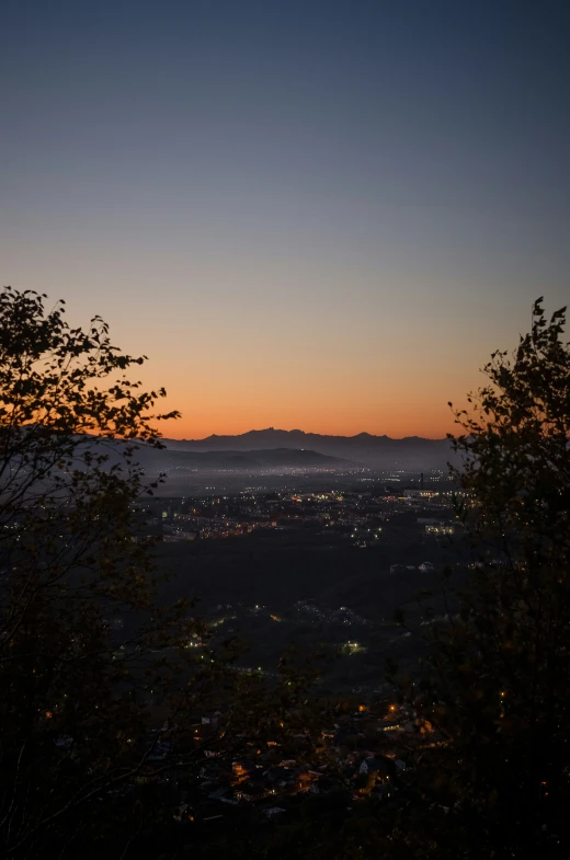 a view over a city and mountains from the top of a hill