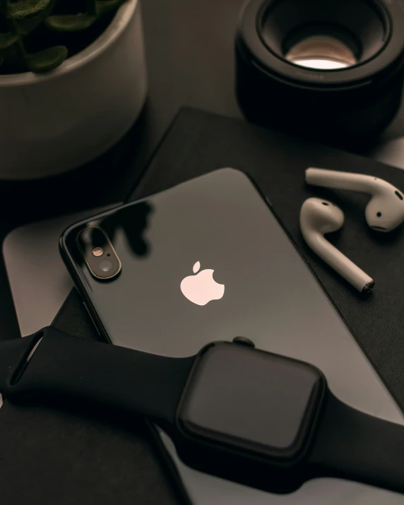 an apple phone with headphones sitting on the table