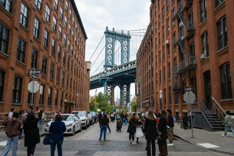 people walking on a city street next to red brick buildings