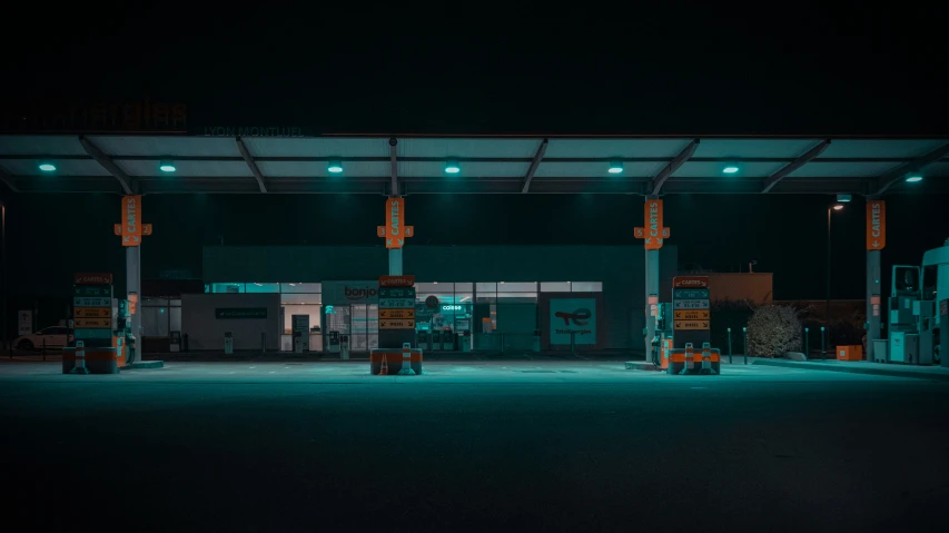 an empty gas station, lit by bright green lights