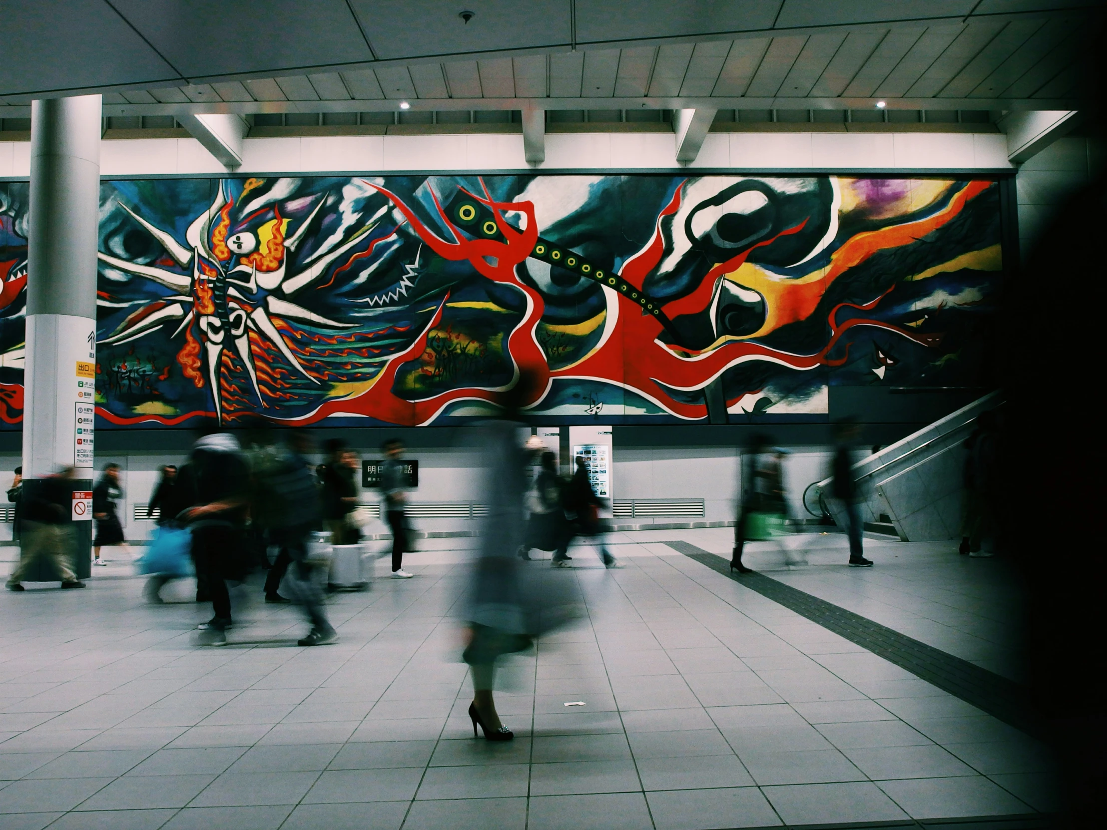 a view inside a train station at night with people walking by