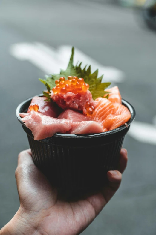 someone holds a small container with a food inside of it