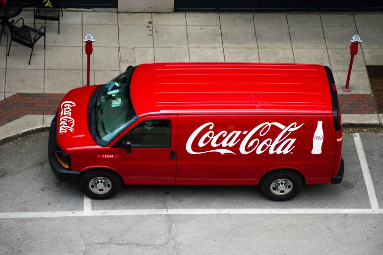 the top view of an orange truck with a coca cola on it