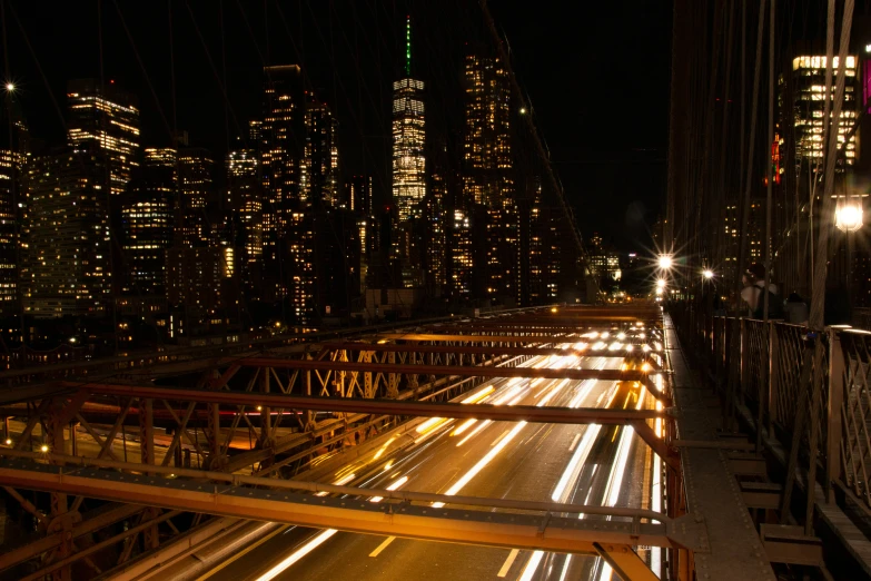 city lights at night are seen on the bridge