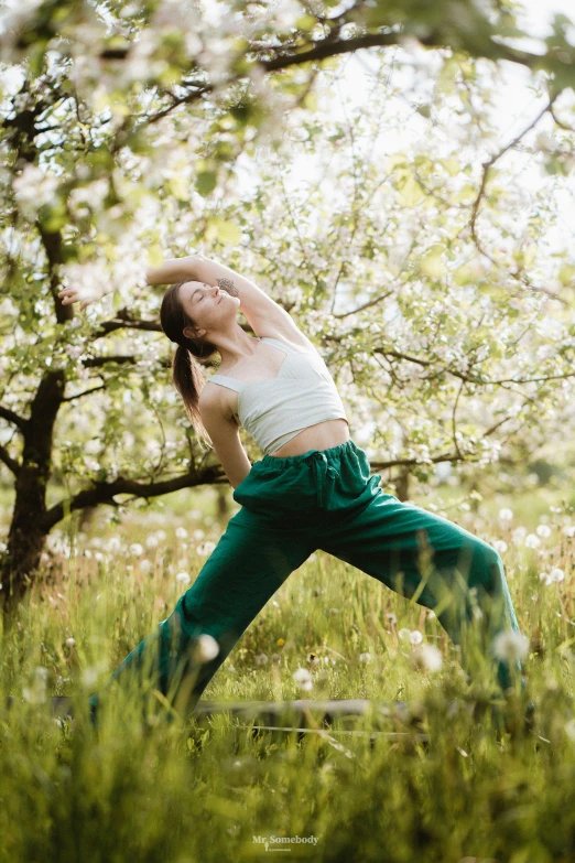 a woman in white shirt doing yoga outside