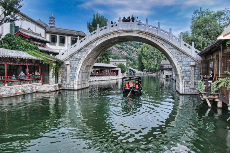 a boat traveling through a canal under a bridge