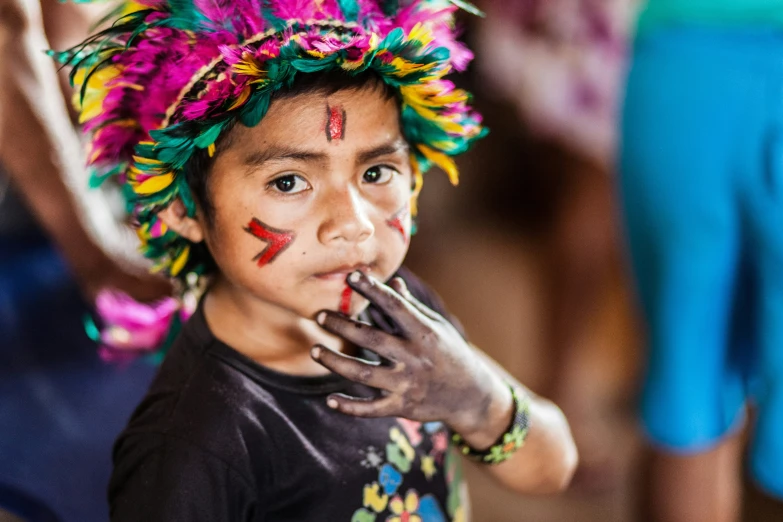 a boy with a painted face stands in front of others