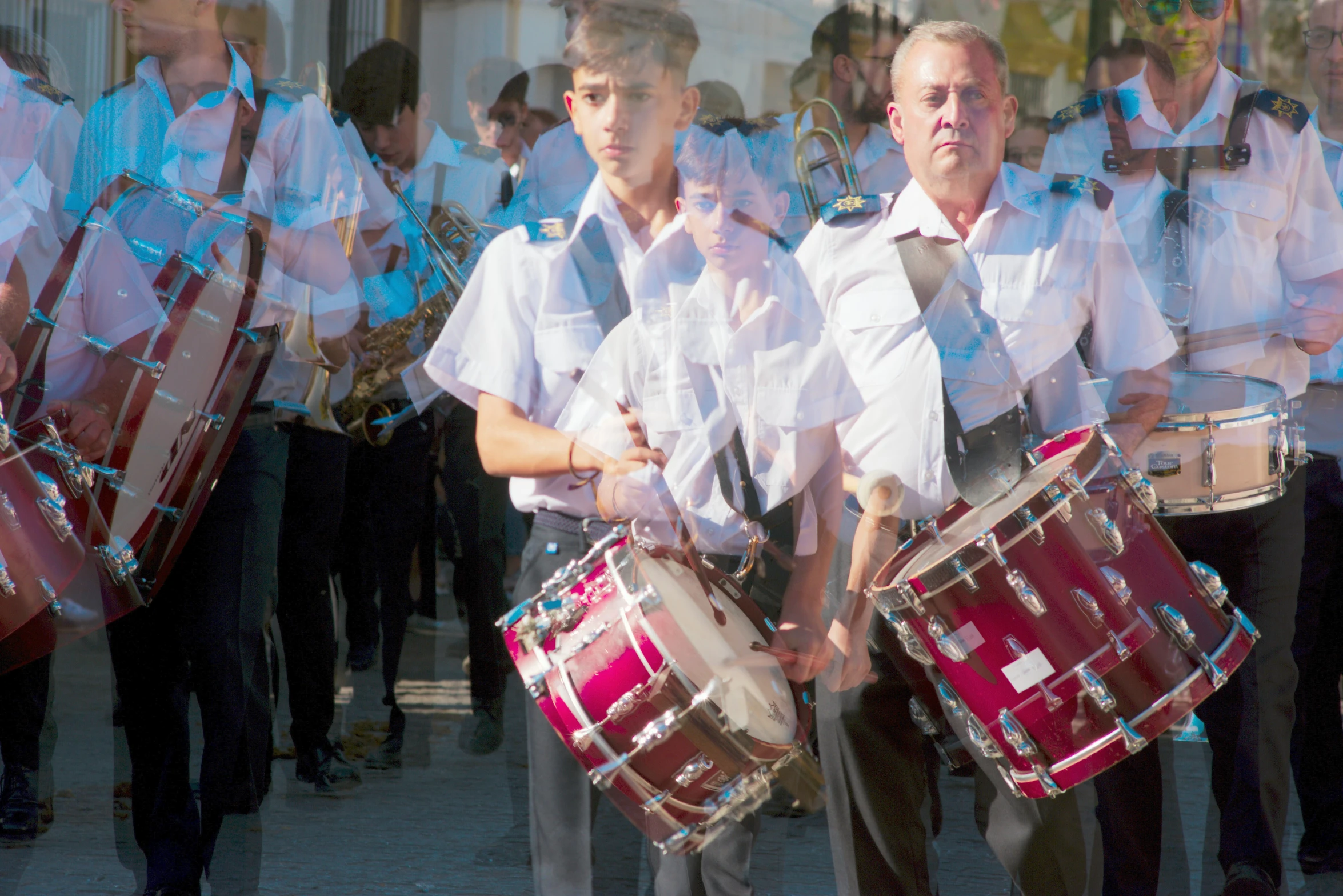 two men are playing musical instruments with some other people behind him