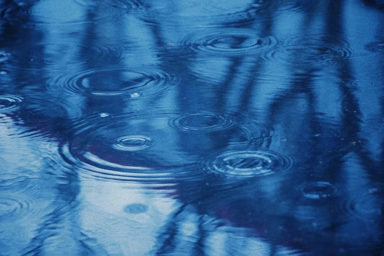 a dark blue background with rain and water ripples