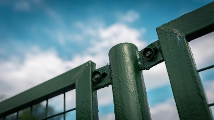 a metal fence is set in front of some sky