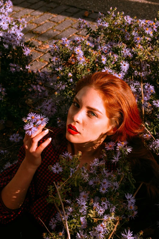 a woman posing with flowers next to a brick road