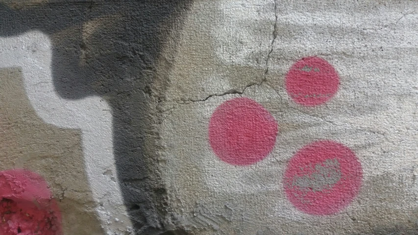 a wall covered in pink paint with pink polka dots