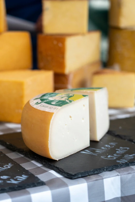 a stack of cheeses on a checkered table cloth