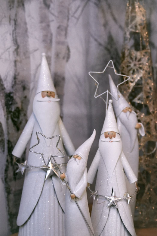 the three white christmas trees are decorated with star shaped ornaments